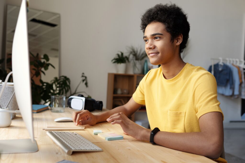 A man sitting at a table with a keyboard and mouse.